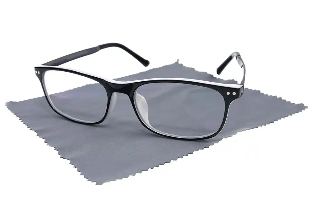 Detailaufnahme einer schwarzen Brille auf einem Brillenputztuch