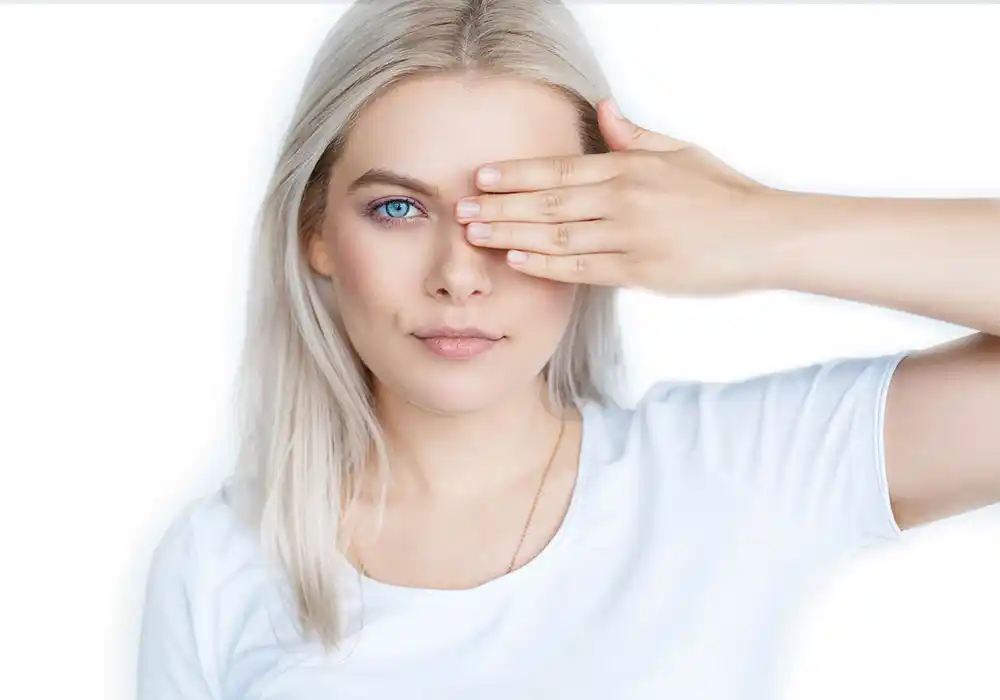 Frau hält sich mit einer Hand ein Auge zu