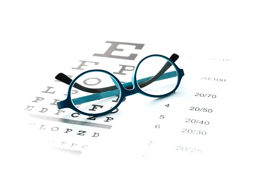 Detailaufnahme einer Brille auf einem Sehtestbogen mit Zahlen und Sehzeichen