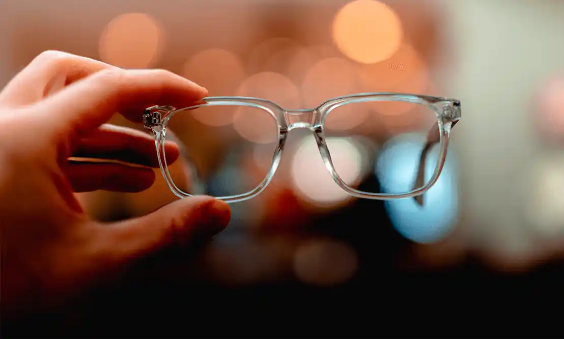 Kundin schaut sich während der Beratung eine Brille genau an