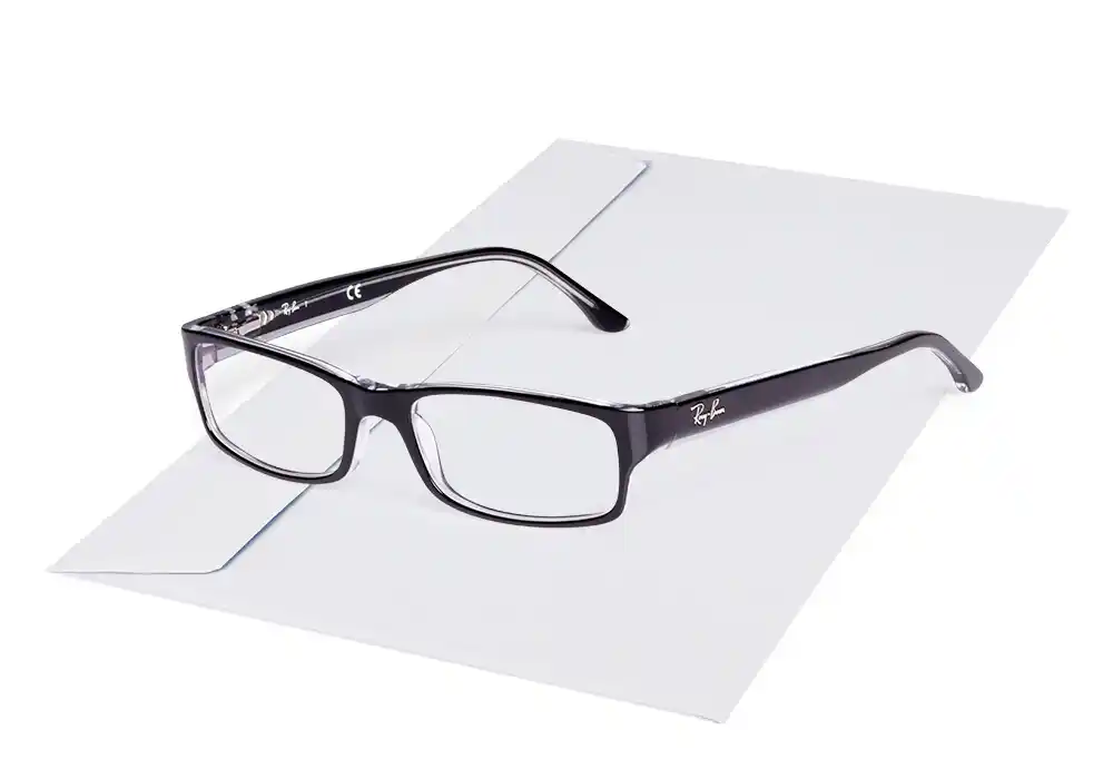 Schwarze Brille liegt auf einem weißen Kuvert